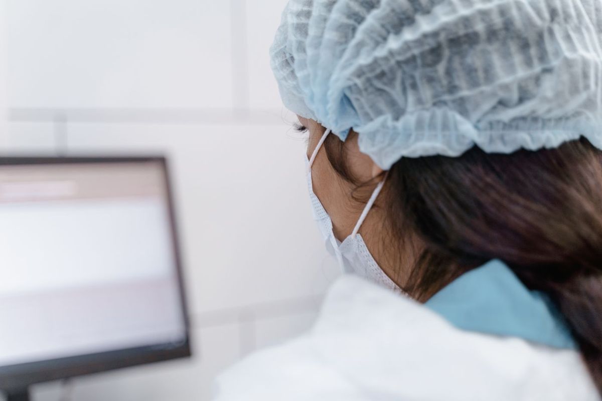 Lab technician reviewing patient and test data on screen during an LIS data migration