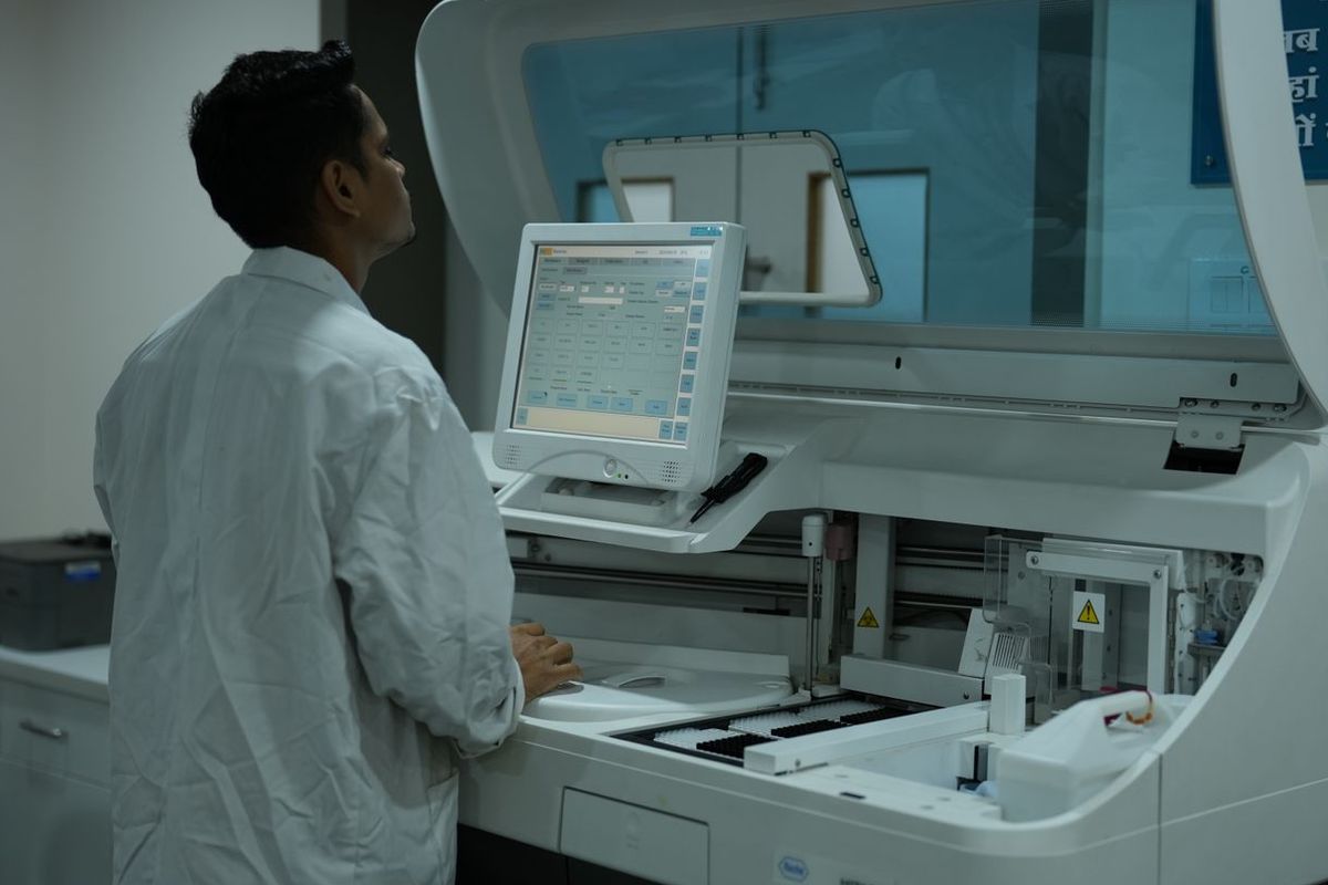 Laboratory technologist at a clinical analyzer connected to the LIS through an instrument interface