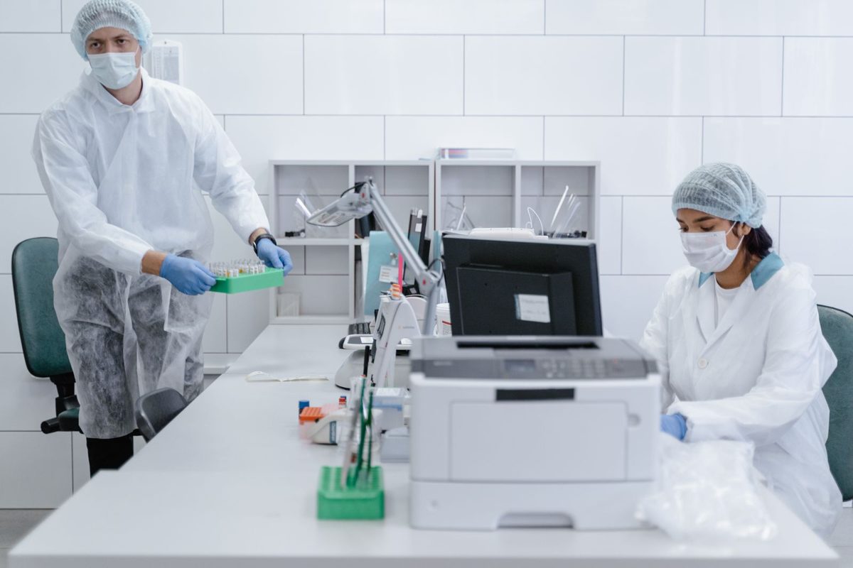 Laboratory staff entering test results at an LIS workstation in a small clinical lab that performs CLIA waived and moderate-complexity testing