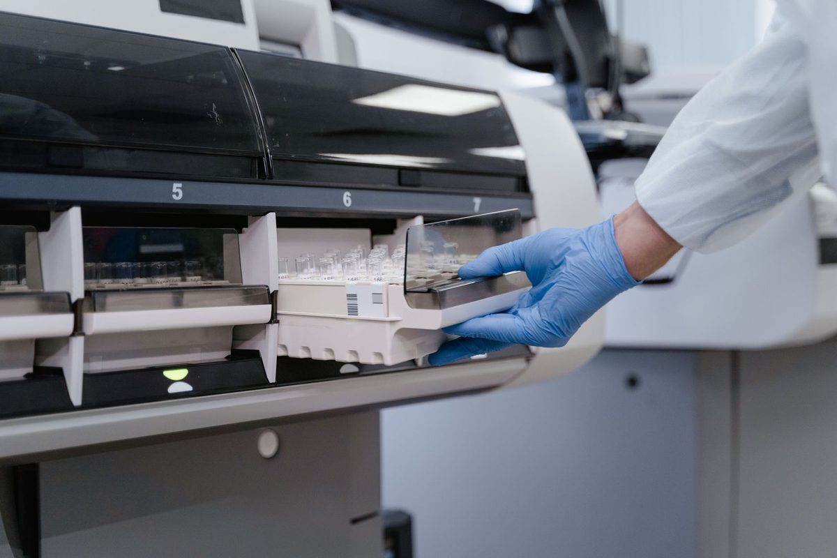 Technologist loading samples into an automated analyzer interfaced to the LIS in a moderate-complexity laboratory